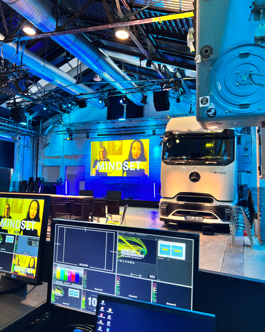 DJ facing a crowd at his deck. Photo with a purple hue